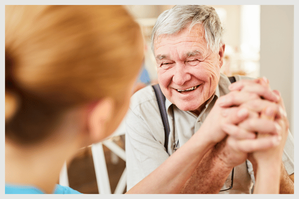 elderly man holding woman's hand